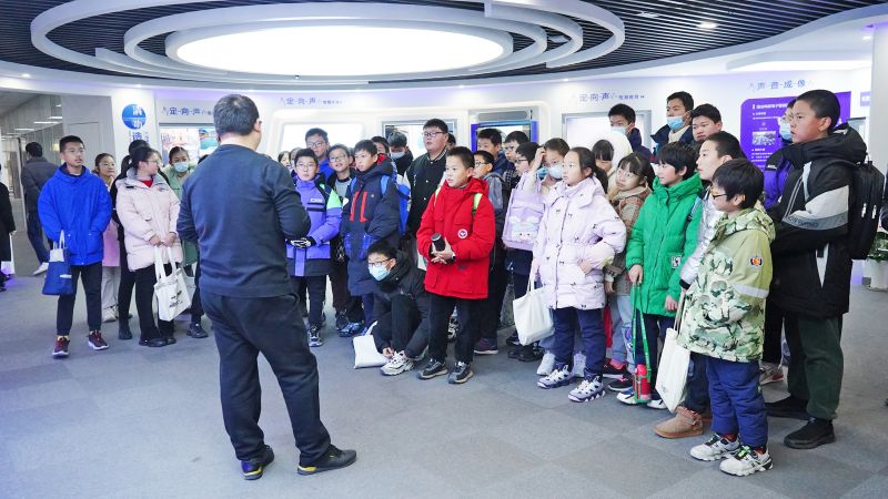 學(xué)生們?cè)谡箯d里聚精會(huì)神地參觀和聽取講解
